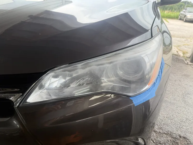 The Camry's other headlight before work, the lens clouded over and taped at the edges