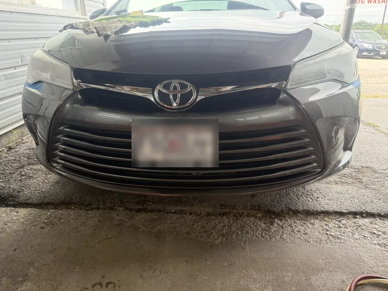 Front of the gray Camry with both headlight lenses clouded and yellowed